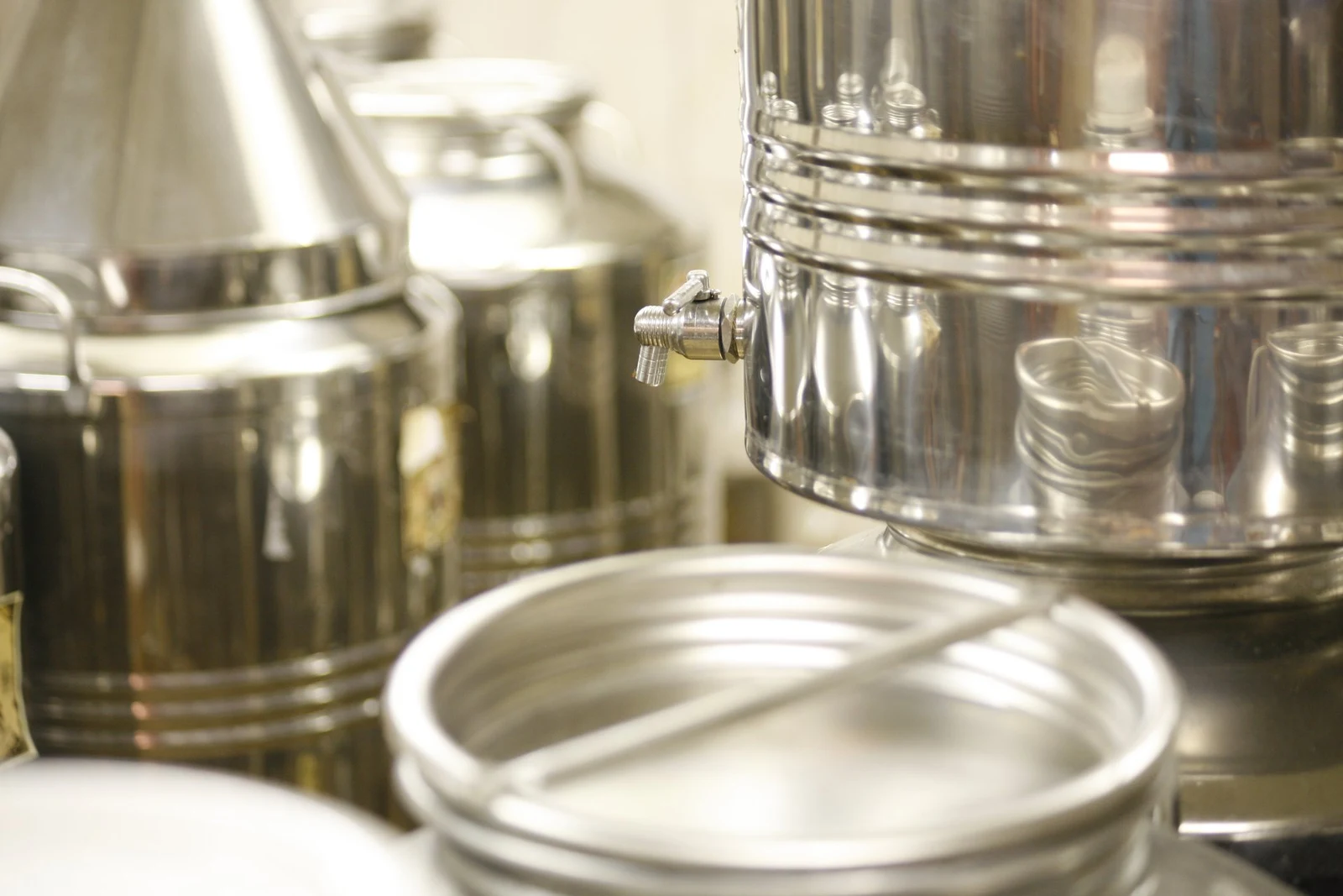 Stainless steel vessels with a close-up of a tap.