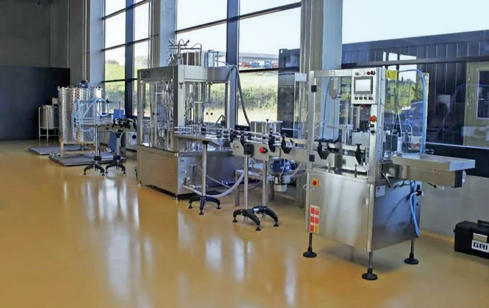 Production equipment in a bright hall with large windows.