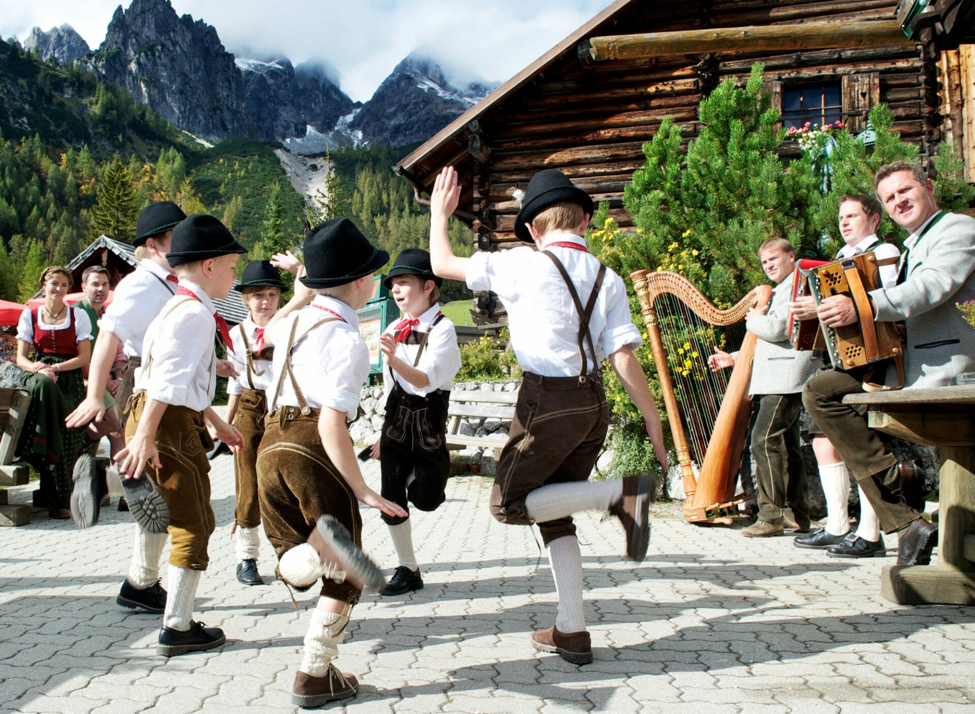 Volkstanz und Musik vor einer österreichischen Almhütte